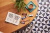 A table with a crossword puzzle, chocolates, and a cup of coffee. Produktbild-Vorschau