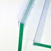 A close-up view of a clear plastic shower door seal with water droplets on it, attached to a green-tinted glass panel. Podgląd zdjęcia produktu