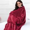 A woman wearing a red hoodie blanket sits on a bed. Produktbild-Vorschau