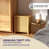 A bedroom scene with a wooden laundry basket and a bedside table with a lamp. Produktbild-Vorschau