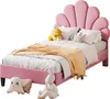 A pink upholstered bed with a shell-shaped headboard, decorated with pillows and a blanket. Voir les images du produit