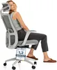 A woman is sitting in an ergonomic office chair, smiling at the camera. A certification tag is hanging from the chair. Podgląd zdjęcia produktu