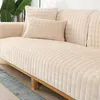 Beiger gesteppter Fleece-Sofabezug auf einem Holzsofa mit passenden Wurfkissen, neben einer grünen Pflanze Náhľad obrázku produktu