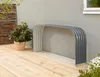 A metal firewood rack is placed on a wooden deck next to a house. Produktbild-Vorschau