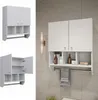 A collage of images showing a white wall-mounted bathroom cabinet with two doors and open shelves, and a towel rack below. The main image shows the cabinet mounted on a tiled wall with toiletries and a towel on the rack. The other images show the cabinet f Produktbild-Vorschau