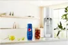 A SodaStream machine with a bottle of Pepsi syrup, a glass of cola, and lemons on a countertop. Produktbild-Vorschau