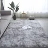 A plush gray rug in a living room setting, with a sofa, plant, and side table. Náhled obrázku produktu