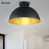 A black ceiling lamp with a gold interior is shown against a white ceiling and wall. Anteprima dell’immagine prodotto