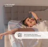 A woman is stretching in bed, looking happy and relaxed. Produktbild-Vorschau