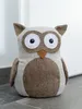 A stuffed owl doorstop sits on a tiled floor in front of a white wall. Anteprima dell’immagine prodotto
