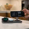 A hand is placing an iPhone on a wireless charging stand that also charges an Apple Watch and AirPods. Voir les images du produit