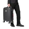 A person in a suit is holding a black suitcase. Anteprima dell’immagine prodotto