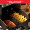 Close-up of a dual-compartment air fryer with french fries in one compartment and a grilled steak in the other. Text overlays highlight a feature. Voir les images du produit