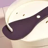 A close-up view of a purple rice paddle resting on a white lid of a rice cooker. Produktbild-Vorschau