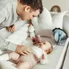 A father is interacting with his baby in a crib. Náhled obrázku produktu