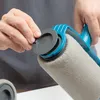 A person's hands are shown operating a paint roller with a refillable reservoir. Voir les images du produit