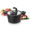 A black pressure cooker is shown in the center, surrounded by ingredients like raw meat, onions, garlic, and herbs. Podgląd zdjęcia produktu