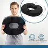 A man is holding a black ring-shaped cushion. There is an inset image showing the cushion with dimensions and icons indicating features. Produktbild-Vorschau