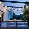 Outdoor patio with string lights, a table, and chairs. Produktbild-Vorschau