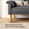 Close-up of a dark gray sofa with wooden legs, showing the gap underneath. Produktbild-Vorschau