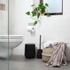 A modern bathroom scene with a toilet, toilet brush, trash can, and laundry basket. Produktbild-Vorschau