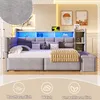 A modern bedroom or living room setting featuring a grey upholstered daybed with integrated storage and LED lighting. Produktbild-Vorschau