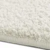 A close-up view of a cream-colored shaggy rug. Produktbild-Vorschau
