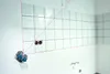 A laser level is set up on a wall with tiles, showing construction or renovation work. Voir les images du produit