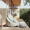 A floral patterned bean bag and ottoman are placed on a wooden deck next to a modern house with large windows and potted plants. Náhľad obrázku produktu