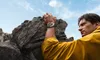 A man is rock climbing and looking at his watch. Podgląd zdjęcia produktu