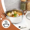 A pot of soup is shown on a white induction cooktop, with jars of dry goods in the background. A circular graphic with a steaming pot icon is in the foreground. Náhled obrázku produktu