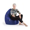 A woman is sitting on a large blue beanbag chair. Produktbild-Vorschau