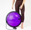 A person is holding a purple balance trainer with black accents and attached resistance bands. Náhled obrázku produktu