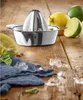 A manual citrus juicer is shown on a wooden table with lemons, limes, mint, and ice. Produktbild-Vorschau