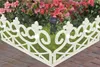 A white decorative garden border with integrated solar lights is placed in front of pink flowers and green foliage. Produktbild-Vorschau
