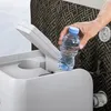 A hand is placing a bottle of water into a compartment on a pool accessory. Produktbild-Vorschau