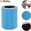 A cylindrical air filter with blue pleated material and a gray top and bottom rim, shown against a white background. Insets show a hand removing protective plastic, a close-up of the blue filter material, and a close-up of the black activated carbon layer. Náhled obrázku produktu
