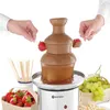 A chocolate fountain with strawberries and grapes being dipped into it. Podgląd zdjęcia produktu