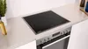 A modern induction cooktop integrated into a kitchen countertop, with an oven below. Produktbild-Vorschau
