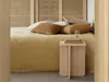 A bedroom scene with a bed, pillows, and a bedside table. Produktbild-Vorschau