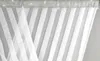 A close-up view of a white striped curtain with a decorative silver trim at the top. Podgląd zdjęcia produktu