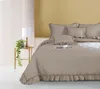 A neatly made bed with taupe bedding and decorative pillows. Podgląd zdjęcia produktu