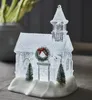 A decorative Christmas church figurine with snow and trees. Produktbild-Vorschau