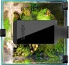 A top-down view of a small aquarium with plants and a light fixture. Voir les images du produit