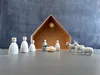 A nativity scene with figures and a stable, set against a dark, textured background. Produktbild-Vorschau