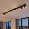 A black track light fixture with four adjustable spotlights mounted on a white ceiling. Náhľad obrázku produktu