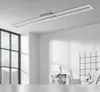 A modern LED ceiling light fixture mounted on a white ceiling, with a large window and a grid shelf visible in the background. Produktbild-Vorschau