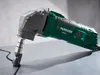 A green and gray metal cutting tool is shown on a light gray surface. Podgląd zdjęcia produktu