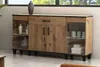 A wooden sideboard with glass doors and a drawer, displayed in a room setting with subtle decor. Produktbild-Vorschau
