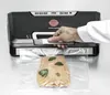 A person using a vacuum sealer machine to seal a package of salmon. Podgląd zdjęcia produktu